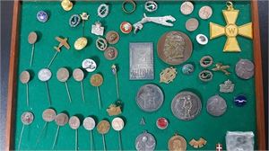 Liten samling olika medaljer, nålar, broscher och andra märken