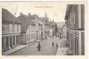 Flekkefjord. Kirkegaden (Kiönig Hansens Bog- og papirhandel  St. Chr-Bergen F 1-II-06.  Flott gatemotIv