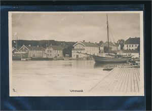 LILLESAND 2 (Anonymt) Viser indre havn med Tollboden og Rådhuset. Ubrukt kort med skadet bakside etter innliming
