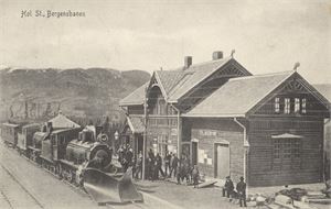 Hol Station, Bergensbanen (N.S. 152) st. Hols Jernbanest. 1913 Frim. fjernet. Topp motiv med to lokomotiv og mange mennesker på stationen.